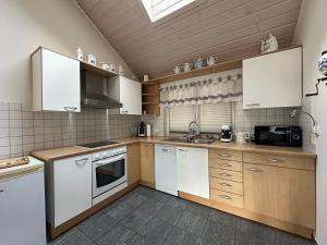 a kitchen with white cabinets and a sink at Pension Schramm in Karlsruhe