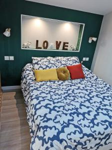 una camera da letto con un letto con un orsacchiotto sopra di Charmante maison-loft paisible et tout confort - Elegant T2 Arradon Golfe du Morbihan ad Arradon