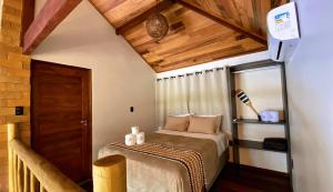 une chambre avec un lit dans une pièce avec des plafonds en bois dans l'établissement Bangalô com Piscina Privativa, à Porto de Pedras 24 autres photos