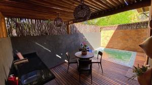 un patio avec une table et des chaises sur une terrasse dans l'établissement Bangalô com Piscina Privativa, à Porto de Pedras