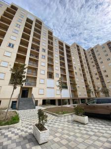 ein großes Gebäude mit einem davor geparkten Auto in der Unterkunft Your beach house holidays with all utilities in Shëngjin