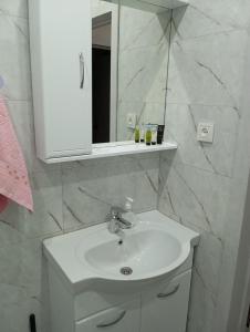 a bathroom with a white sink and a mirror at Новые апартаменты в центре города Кокшетау in Kokshetau