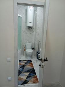a bathroom with a toilet and a sink at Новые апартаменты в центре города Кокшетау in Kokshetau
