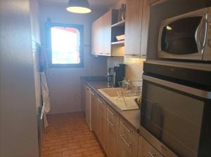 a kitchen with a microwave and a sink at Collioure, entre mer, piscine & montagne in Collioure