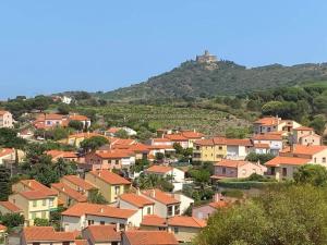a large town with houses on a hill at Collioure, entre mer, piscine & montagne in Collioure
