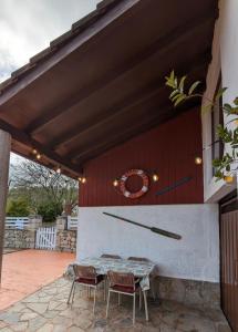 La Acebosa的住宿－Casa de campo La Casuca Del Monje，天井设有两把椅子和一张桌子,遮阳篷下方