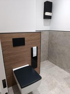 a bathroom with a toilet and a tv on the wall at Apartment Sofia in Düsseldorf