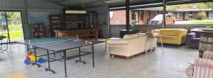 Cette chambre comprend une table de ping-pong et des chaises. dans l'établissement Halls Haven Tiny House 2, à Halls Gap