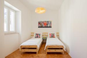 2 Einzelbetten in einem Zimmer mit weißen Wänden in der Unterkunft Zadar Center Apartment in Zadar