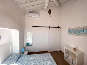 a bedroom with a bed and a white wall at Casa Angè - Lerici, Golfo dei Poeti in Lerici