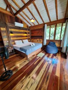 a bedroom with a bed in a wooden cabin at Woodstock Bungalow - Barra Grande - condo frente praia in Barra Grande