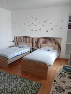 Un dormitorio con dos camas y una alfombra. en Maison EL Marielle, en Vierzon