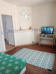 ein Wohnzimmer mit einem TV und einem Tisch in der Unterkunft Maison EL Marielle in Vierzon