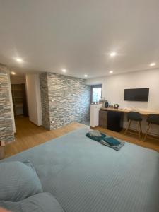 1 dormitorio con 1 cama grande y pared de piedra en Chambre Mendi pausa en Irissarry