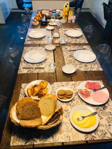 una mesa larga con pan y otros alimentos. en B&B Pegasus II - Chambre de luxe avec sauna privatif, en Vielsalm