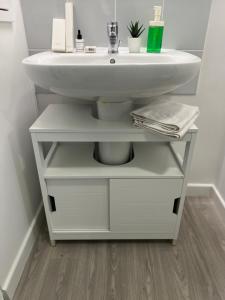 a bathroom with a white sink and a shelf at Superbe 3 pièces avec balcon pour 5 personnes in Villiers-le-Bel +30 photos