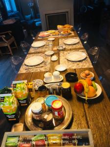 a long wooden table with food on top of it at B&B Pegasus II - Chambre de luxe avec sauna privatif in Vielsalm