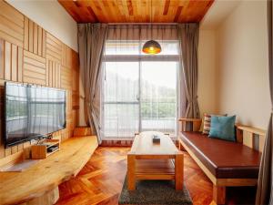 a living room with a couch and a large window at Bay Forest Boutique B&B in Hengchun