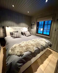 um quarto com uma cama grande e um cobertor peludo em Nymon Mountain Lodge em Stöten