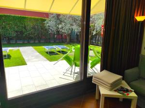 una ventana con vistas al patio, mesa y sillas en Bardolino Wein Apartments, en Bardolino