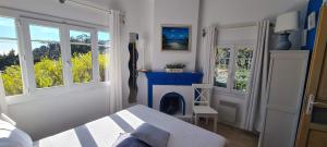 a bedroom with a fireplace and a bed and windows at Villa Adriandre in Rayol-Canadel-sur-Mer