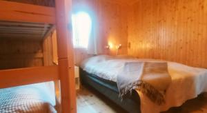 a bedroom with two bunk beds and a window at Nusfjord Waterfront Rorbu 18 in Nussfjord