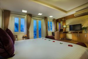 una camera da letto con un grande letto bianco con rose sopra di Eliana Ruby Hotel & Travel a Hanoi