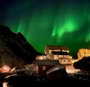 una imagen de una casa con la aurora en el cielo en Nusfjord Waterfront Rorbu 18, en Ramberg