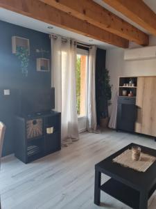 a living room with a table and a large window at Maison classée 2 étoiles proche du lac du Salagou in Clermont-lʼHérault