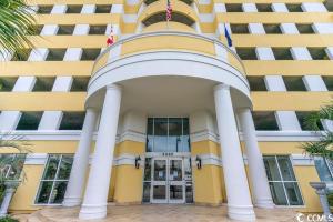 a yellow and white building with columns at Camelot By The Sea - Blue C in Myrtle Beach