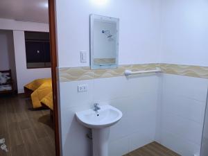 uma casa de banho com um lavatório e um espelho na parede em LOS NEVADOS II em Huaraz
