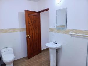 uma casa de banho com um WC e um lavatório em LOS NEVADOS II em Huaraz