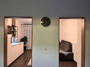 ein Wohnzimmer mit einem Sofa und einer Uhr an der Wand in der Unterkunft Zentrale Stadtwohnung, Bahnhofsnähe, OG-Krankenhaus, OG-Messe, EuropaPark in Offenburg