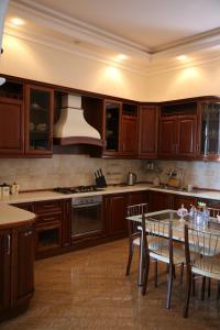 a kitchen with wooden cabinets and a table with chairs at Exciting seaview villa Aymesa in Baku
