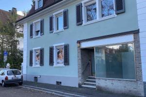 a white house with windows and a car parked outside at Zentrale Stadtwohnung, Bahnhofsnähe, OG-Krankenhaus, OG-Messe, EuropaPark in Offenburg