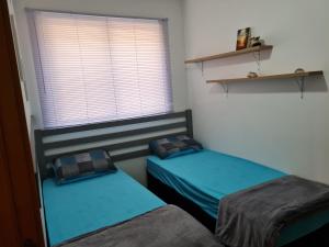 2 aparte bedden in een kamer met een raam bij Garden pé na areia in Barra Velha