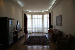 a living room with a couch and a television at Exciting seaview villa Aymesa in Baku