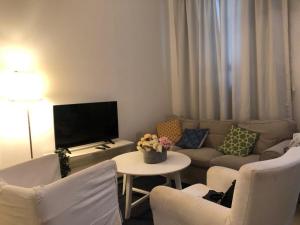 a living room with a couch and a table with chairs at דירה נעימה לזוג בין נווה צדק לנחלת בניימין in Tel Aviv