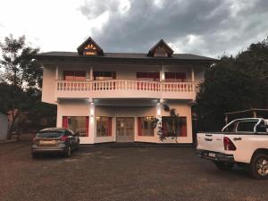 Puerto Libertad的住宿－Hotel Puerto Libertad - Iguazú，前面有停车位的房子