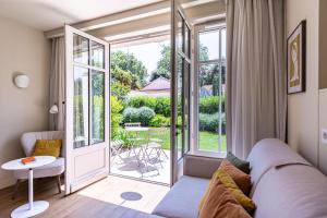 a living room with a couch and a sliding glass door at La Villa du Moulleau in Arcachon