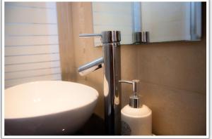 uma casa de banho com um lavatório, um espelho e um lavatório branco em דירה נעימה לזוג בין נווה צדק לנחלת בניימין em Tel Aviv