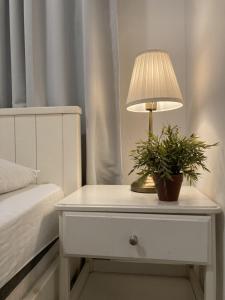 uma lâmpada sobre uma mesa de cabeceira com uma planta sobre ela em דירה נעימה לזוג בין נווה צדק לנחלת בניימין em Tel Aviv