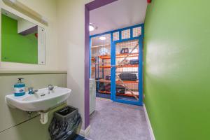 La salle de bains est pourvue d'un lavabo et d'une cage pour chats. dans l'établissement Pax Lodge, à Londres