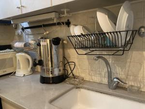 a kitchen counter with a sink and a plate rack at דירה נעימה לזוג בין נווה צדק לנחלת בניימין in Tel Aviv