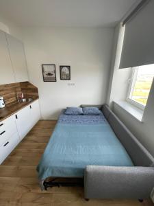 a small bedroom with a bed and a window at Airport Apartment 25 Self Check-In Fee Parking in Vilnius