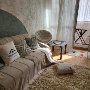 ein Wohnzimmer mit einem Sofa und einem Stuhl in der Unterkunft GILMORE Home - close to PARIS center in La Courneuve