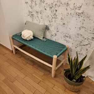 a bench in a room with a pillow and a plant at GILMORE Home - close to PARIS center in La Courneuve