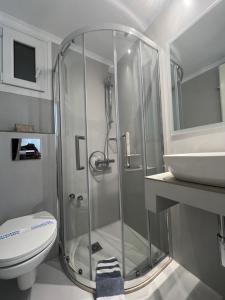 a bathroom with a shower and a toilet and a sink at Sailor's Nautical Concept in Spetses