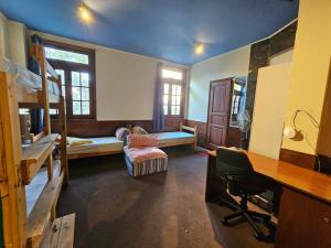 a dorm room with bunk beds and a desk and a desk at Montevideo Hostel in Montevideo
