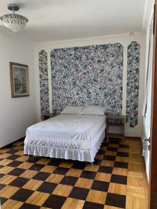 um quarto com uma cama com uma parede floral em Hotel pousada Krone Praia de Iracema Fortaleza em Fortaleza